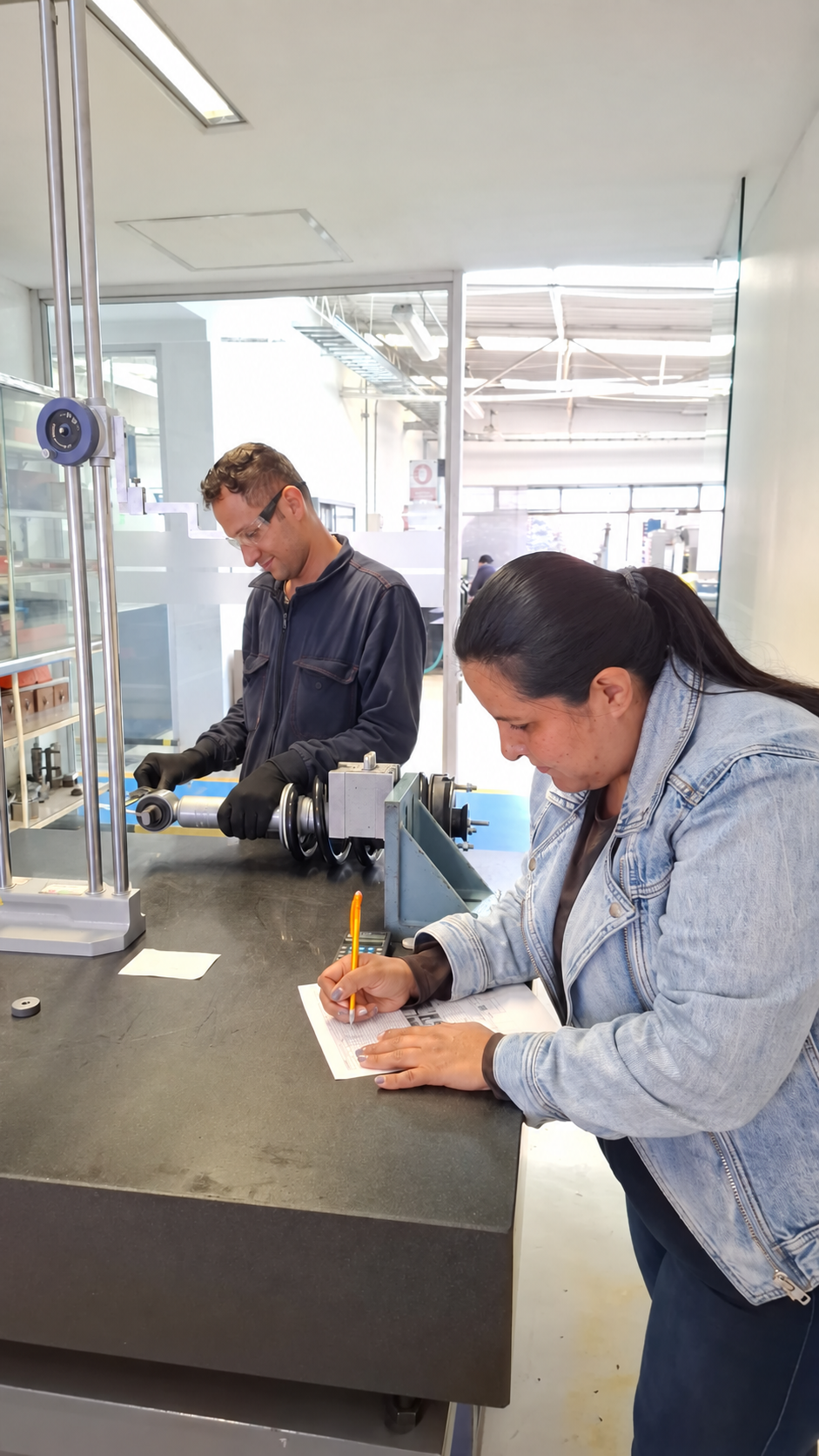 Ing. Liliana Vanegas documentando la inspección de un conjunto de suspensión en una fábrica latinoamericana